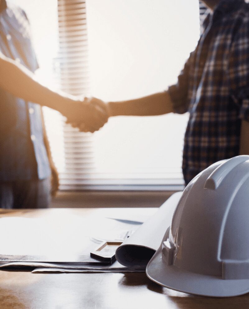 Handshake over restoration plans and a hard hat