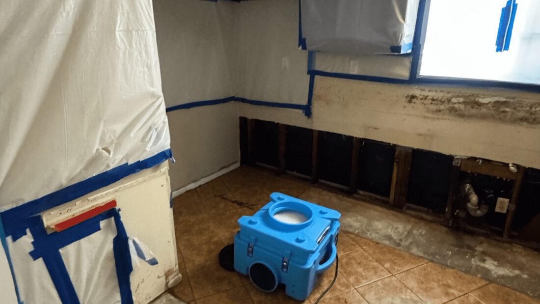 Containment barriers and an air scrubber running in a damaged room